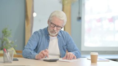 Senior Old Man Doing Calculation Work on Documents