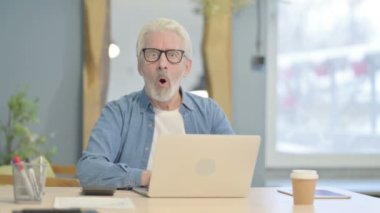 Shocked Senior Old Man Looking at Camera While Working on Laptop