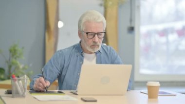 Male Graphic Designer Working on Laptop and Graphic Tablet