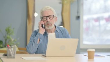 Senior Old Man Talking on Phone to Discuss Work