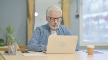 Senior Old Man Typing on Laptop in Office