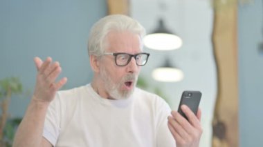 Portrait of Senior Old Man Upset by Loss on Smartphone