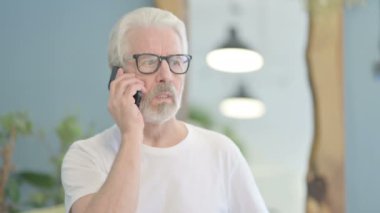 Telefonda konuşan yaşlı bir adamın portresi.