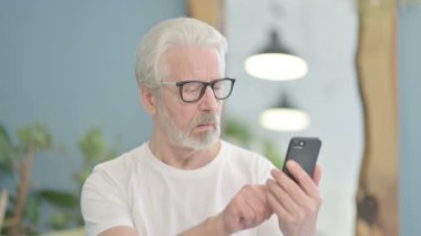 Smartphone kullanan yaşlı adamın portresi