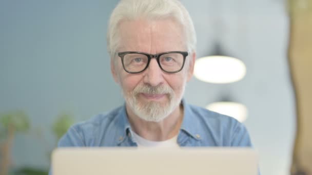 Close Senior Old Man Smiling Camera While Using Laptop — Stockvideo