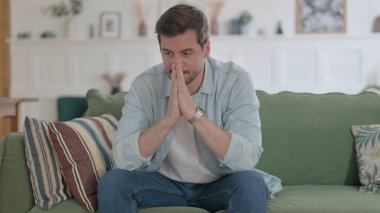 Casual Man Feeling Upset while Sitting on Sofa
