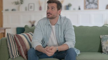 Casual Man Feeling Upset while Sitting on Sofa