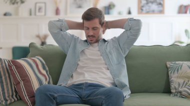 Casual Man Feeling Upset while Sitting on Sofa