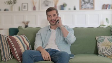 Casual Man Talking on Phone on Sofa