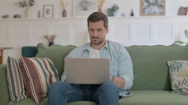 Casual Man Working on Laptop on Sofa