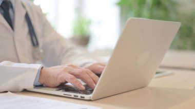 The Close Up of Old Doctor Typing on Laptop