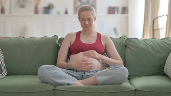 Pregnant Woman Stroking Her Tummy While Sitting Sofa — Stockfoto