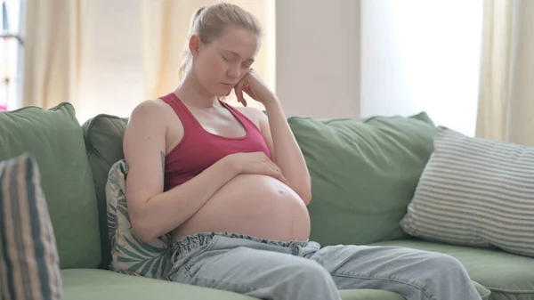 Pregnant Woman Sleeping while Sitting on Sofa