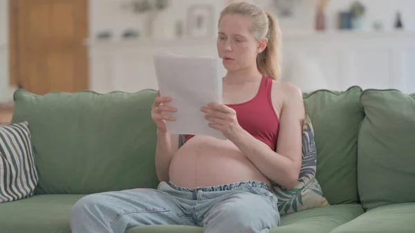 Pregnant Woman Reading Medical Report at Home, Documents