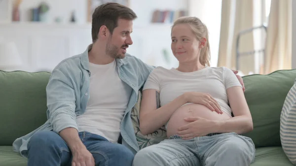 Pregnant Woman and Husband Talking with Each other at Home