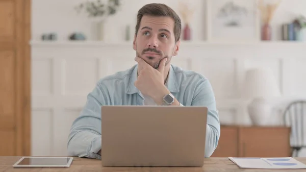 Hombre Joven Casual Pensando Mientras Trabaja Ordenador Portátil Oficina —  Fotos de Stock