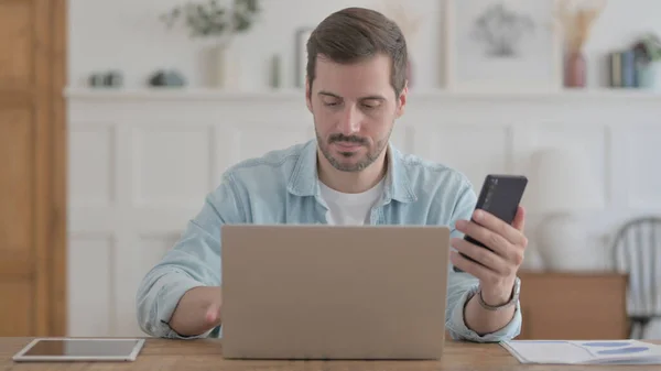 Casual Man Using Smartphone While Using Laptop — Photo