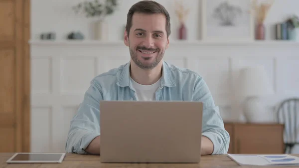 Casual Man Smiling Camera While Using Laptop —  Fotos de Stock