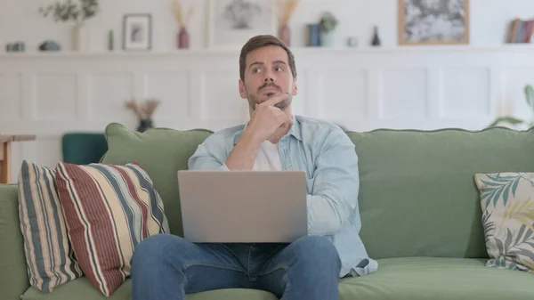 Casual Man Thinking While Working Laptop Sofa — Stockfoto