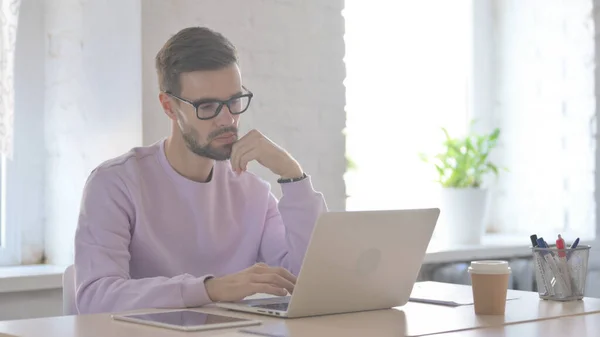 Young Adult Man Thinking While Working Laptop — Stock Photo, Image