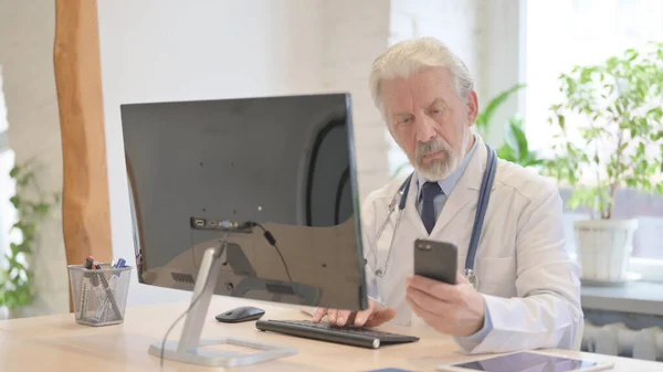 Old Doctor Using Smartphone Work Clinic — Fotografia de Stock