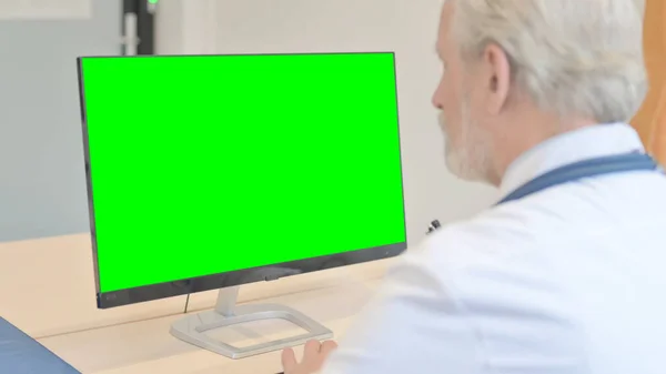 The Old Doctor Working on Desktop with Chroma Key Screen