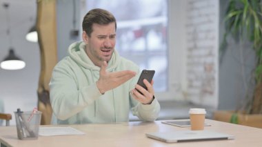 Upset Young Adult Man Reacting to Loss on Smartphone