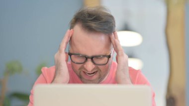 Close Up of Young Adult Man having Headache while Working on Laptop