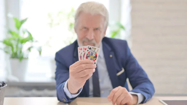 The Old Businessman showing Poker Cards in Office