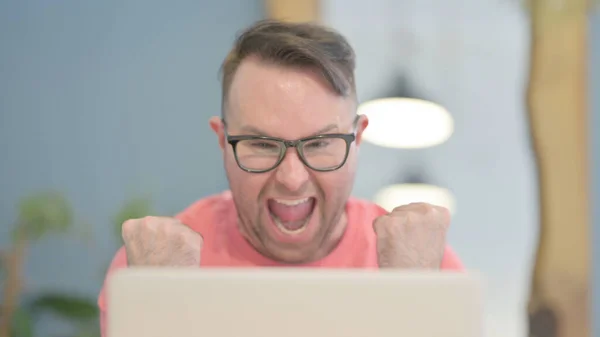 Close Up of Young Adult Man Celebrating Success on Laptop