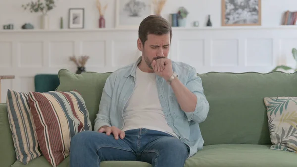 Casual Man Coughing while Sitting on Sofa