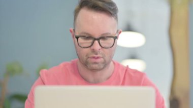 Close Up of Young Adult Man having Headache while Working on Laptop