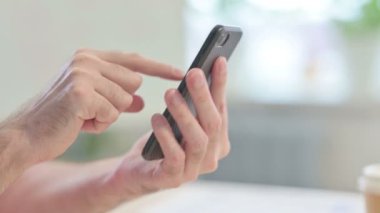 Close up of Young Adult Man Browsing Internet on Smartphone