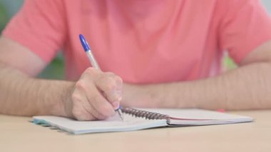 Close up of Young Man Writing in Office