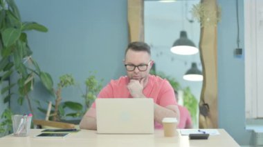 Creative Adult Man Thinking while Working on Laptop