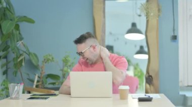 Creative Adult Man having Neck Pain while using Laptop