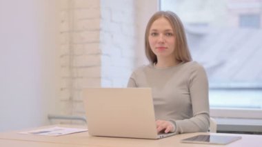 Creative Young Woman Showing Heart Sign while using Laptop