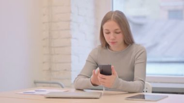 Successful Creative Young Woman Celebrating Win on Smartphone