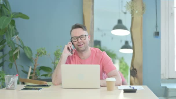 Creative Adult Man Talking Phone While Using Laptop — Vídeo de Stock