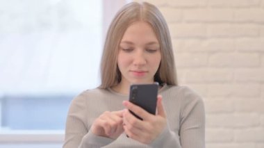 Portrait of Creative Young Woman Celebrating Success on Smartphone