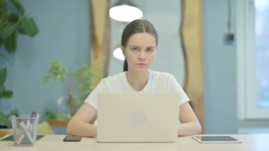 Young Woman Shaking Head in Denial at Work