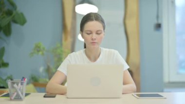 Shocked Young Woman Looking at Camera While Working on Laptop