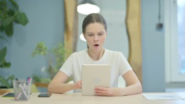 Young Woman Shocked by Loss on Digital Tablet