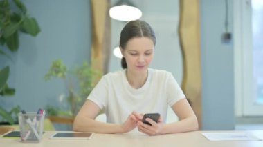 Successful Young Woman Celebrating Win on Smartphone