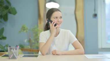 Young Woman Talking on Phone Discussing