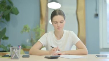 Young Woman Doing Calculations at Work