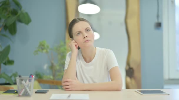Junge Frau Denkt Sitzen Bei Der Arbeit Nach — Stockvideo
