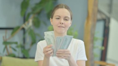 Portrait of Young Woman Counting Dollar