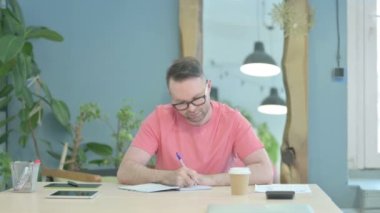Creative Man Writing while Sitting in Office