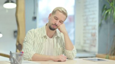 Genç adam çalışırken uyuyor.